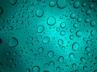 Very beautiful water dots on the glass in focus in extremely saturated blue color