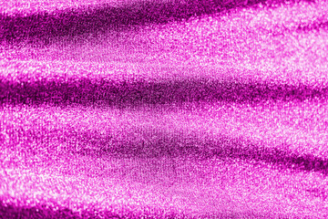 Colored raspberry pink magenta shiny fabric texture with folds. Surface background colors of the year 2021.