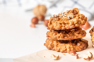 Homemade oat cookies with various nuts and sesame seeds close-up. Free space for text. Tasty and healthy dessert, vegetarian and vegan food.