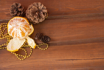 fir-tree cones and tangerine on a wooden table. New Year 2021. Christmas mood

