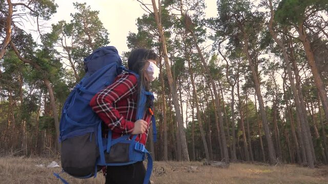 tourist hiker girl goes for a walk near a hiking backpack forest park. concept pandemic virus epidemic world lifestyle catastrophe infection covid