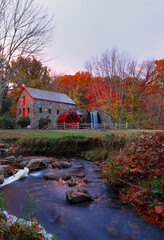 The Wayside Inn Grist Mill with water wheel and cascade water fall in Autumn at sunrise, Concord Massachusetts USA