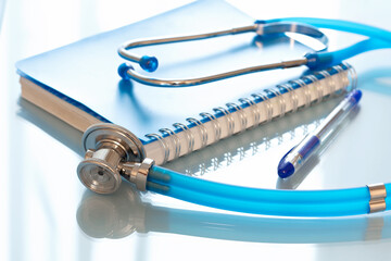Stethoscope with notepad on a blue background.