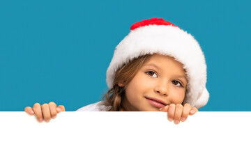 A little girl in a Christmas hat looks out from behind the background.
