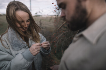 a couple in love walks in an open soybean field in the evening in cloudy weather