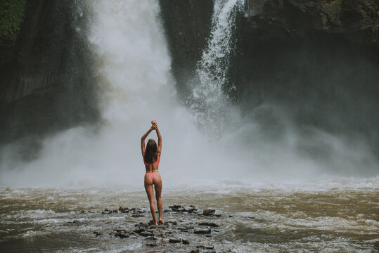 Beautiful girl having fun at the waterfalls in Bali. Concept about wanderlust traveling and wilderness culture