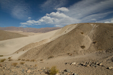 Enchanting view of the arid desert. The yellow sand dune and hills under a magical blue sky. 