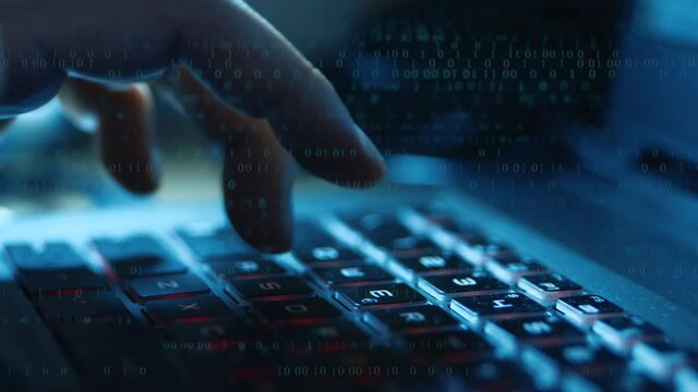 Man typing on computer keyboard with binary code overlay. Slow motion shooting with dolly motion.
