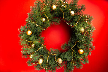 Fototapeta na wymiar Beautiful Christmas wreath on red background. Christmas holidays composition