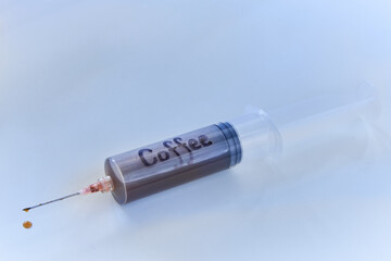 Syringe filled with coffee on white background.