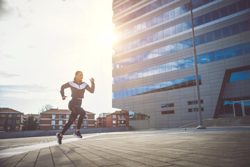 Fototapeta na wymiar Female urban runner training in the city center