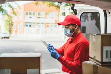 Delivery man wearing face protective mask to avoid corona virus spread - Young express courier...