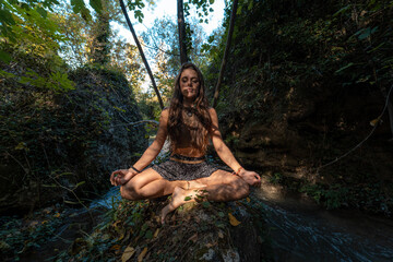 Strong woman practicing yoga in nature with a beautiful sunset.