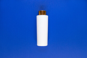 Bottle for liquid, cream, gel, lotion. Сosmetic bottle on blue background.  SPA cosmetic product branding mockup.
Flat lay minimalist style.