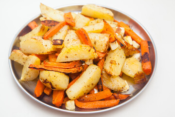 plate with freshly baked potatoes with carrots on white