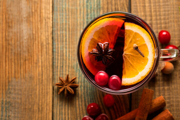 Glintwein with winter spices on a wooden background with a place for a close-up text. Warming Christmas German drink with cinnamon, anise and cloves.