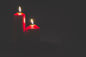 two red candles burning on black background
