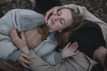 a couple in love walks in an open soybean field in the evening in cloudy weather