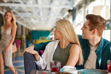 blonde caucasian woman came to friends sitting in cafe, say hello, greet each other, haven't seen a long time. meeting in cafe, birthday party