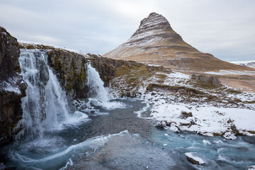 panoramic views of iconic waterfall Kirkjufellsfoss and distinctly shaped mountain