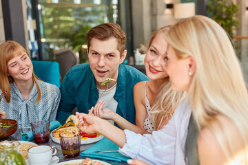 happy young caucasian friends gathering in cafe, sitting at table, chatting, talking.they are spending funny time, students or best friends meeting