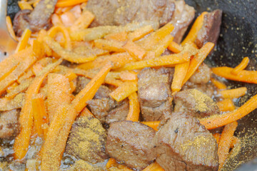 Cooking pilaf in a cauldron on the grill outside in the summer