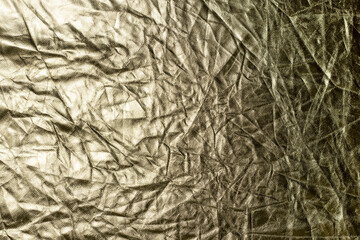 Golden crumpled foil paper texture background. Abstract backdrop.