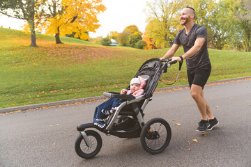 man with her daughter in jogging stroller outside in autumn nature