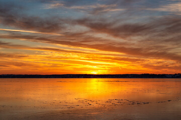 Fototapeta premium sunset over the ice on lake