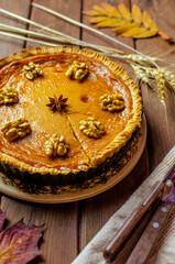 Fresh Homemade Pumpkin Pie on rustic wooden background made for Thanksgiving or halloween.