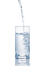 Fresh water pouring in glass isolated on white