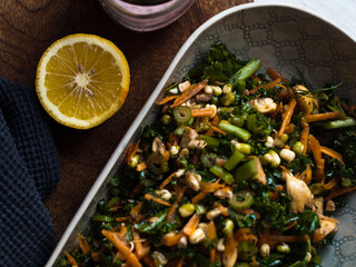 Raw organic kale, carrot and mushroom salad in natural light.