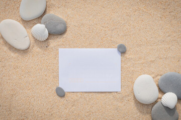 Arrière-plan grains de sable de mer, sable fin de plage avec enveloppe et galets. Emplacement pour texte sur papier.