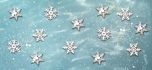 Pattern from wooden snowflakes on a light blue background. Christmas wooden figurines. Creative copy space.