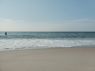Fototapeta na wymiar City Beach, Rockaway beach, quiet and empty ocean with a peaceful glow in the background. New York