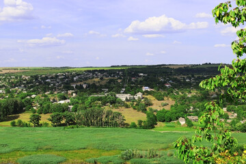 Fototapeta na wymiar landscape with field and blue sky. A moldovan village is near