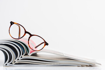 Open magazine with reading glasses on top