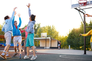 slam dunk. young caucasian basketball players, boys throwing ball into basketball hoop at...