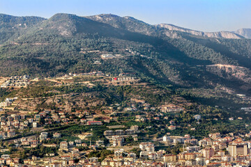 Fototapeta na wymiar View of the roofs and the city of Alanya in Turkey from the height of the mountains