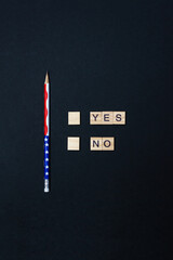 Words Yes No made of wooden blocks and pencil on black background. Decision making concept. Vertical banner