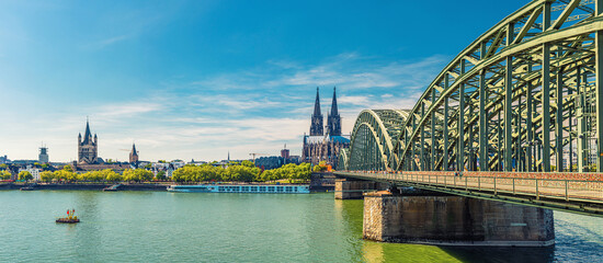 Panorama of Cologne city historical centre with Cologne Cathedral of Saint Peter, Great Saint Martin Roman Catholic Church buildings and Hohenzollern Bridge across Rhine river. Cologne panoramic view