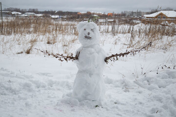 A snowman stands in the snow.Fun and recreation in winter.