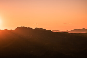 Obraz premium Beautiful Mountain And Sunset at swiss Alps. Dark Silhouette of Mountains on Yellow Sunrise Background