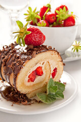 Cake Roulade with chocolate and strawberries on the white background