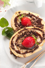 Cake Roulade with chocolate and strawberries on the white background