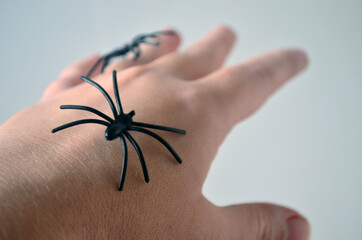 Black spiders on a female hand. Horror, fear, Halloween.