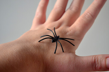 Black spiders on a female hand. Horror, fear, Halloween.