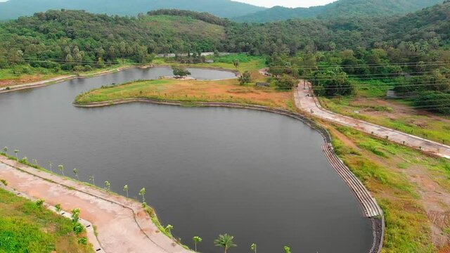 flyaway drone shot  birds-eye view  transmission tower power grid power line by the lake over the mountain jungle