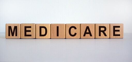 Wooden cubes with word 'medicare'. Beautiful white background. Medical concept. Copy space.
