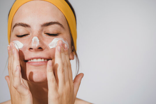 Young Woman Putting Face Cream
